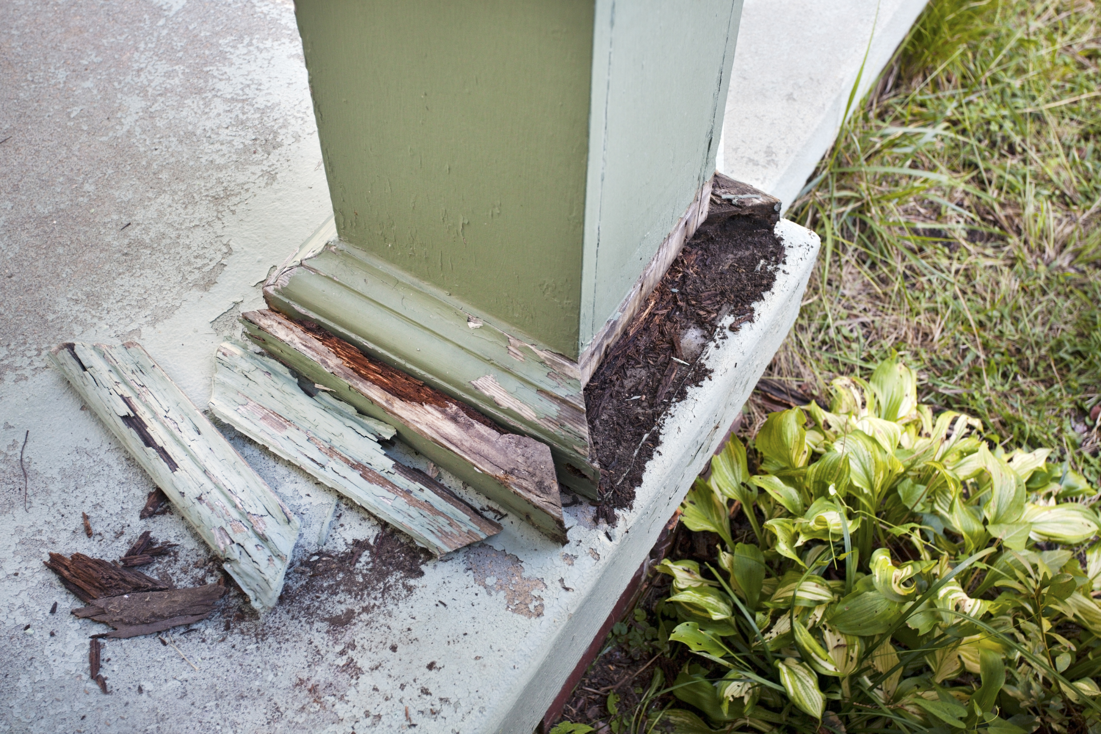 Detail of column post damage on home's front porch.